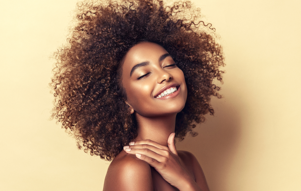 A woman smiles, showing off the results of her professional teeth whitening treatment