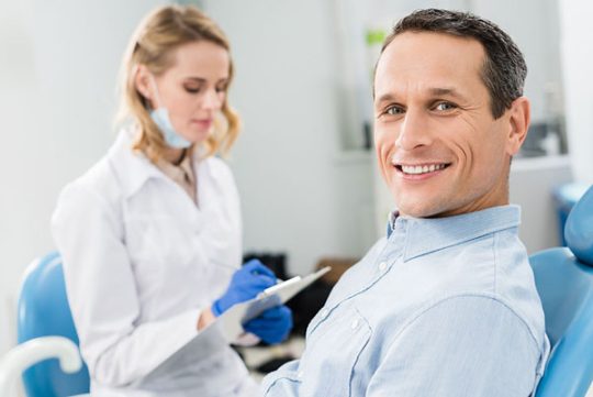 middle-aged man smiling at his dental visit